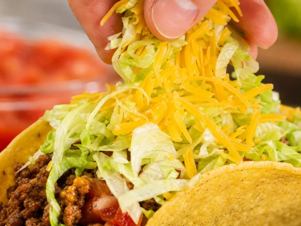 Topping Tacos with Lettuce and Cheese
